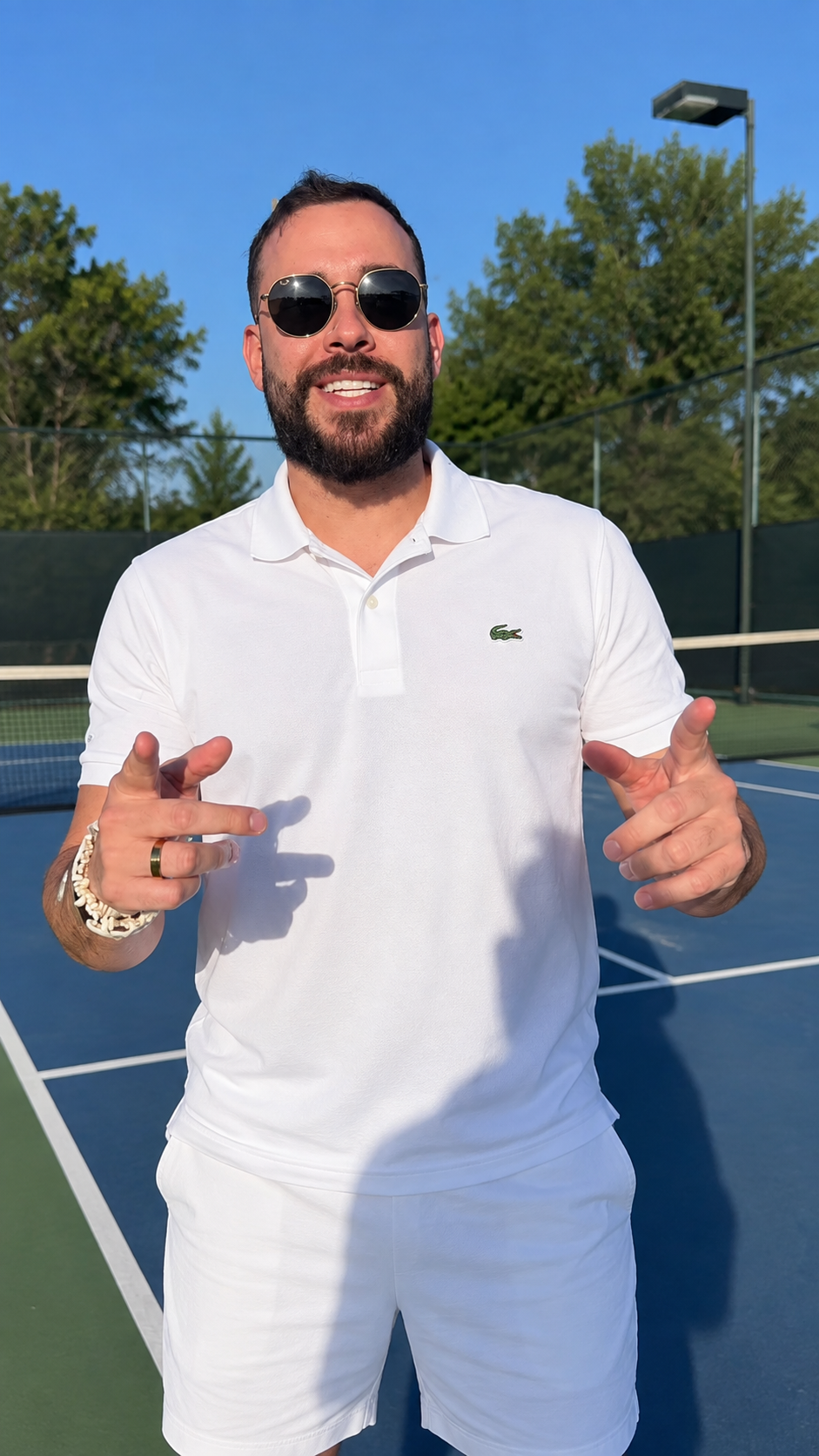 Mateus usando camisa Lacoste em uma quadra de tênis